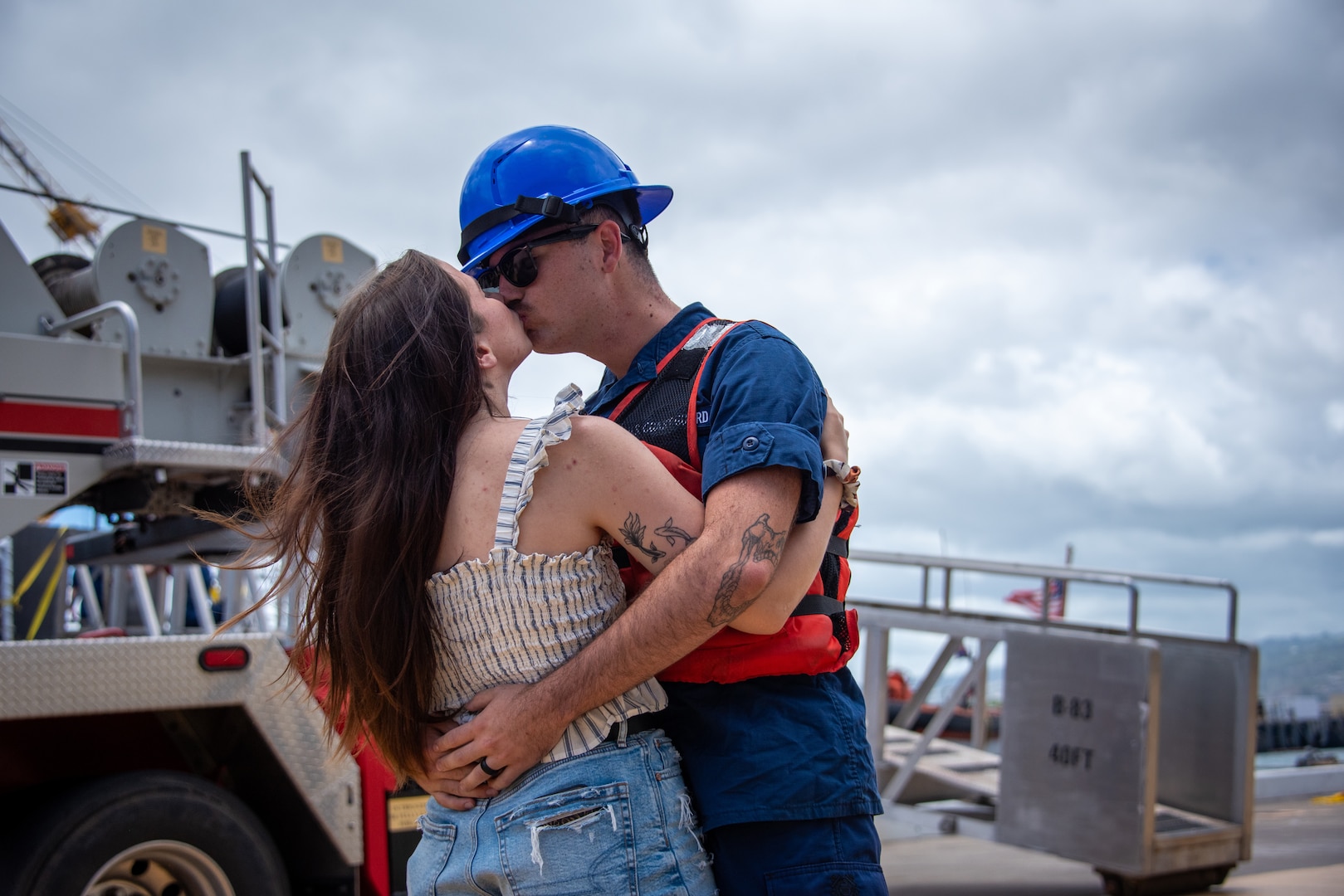 A U.S. Coast Guardsmen assigned to medium endurance cutter USCGC Harriet Lane (WMEC 903) embraces his wife at the pier on Joint Base Pearl Harbor-Hickam in Honolulu, Hawaii, July 9, 2025. The Harriet Lane crew returned from a 73-day patrol in Oceania during which they made port calls in French Polynesia, Cook Islands, and American Samoa. (U.S. Coast Guard photo by Chief Petty Officer Corinne Zilnicki)