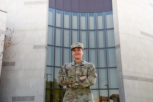 An Airman poses for a photo in front of the base chapel.
