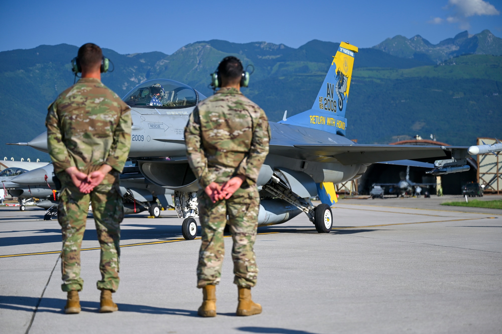 two maintainers stand in front of F-16