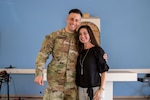 Service member smiles next to a woman in a black shirt