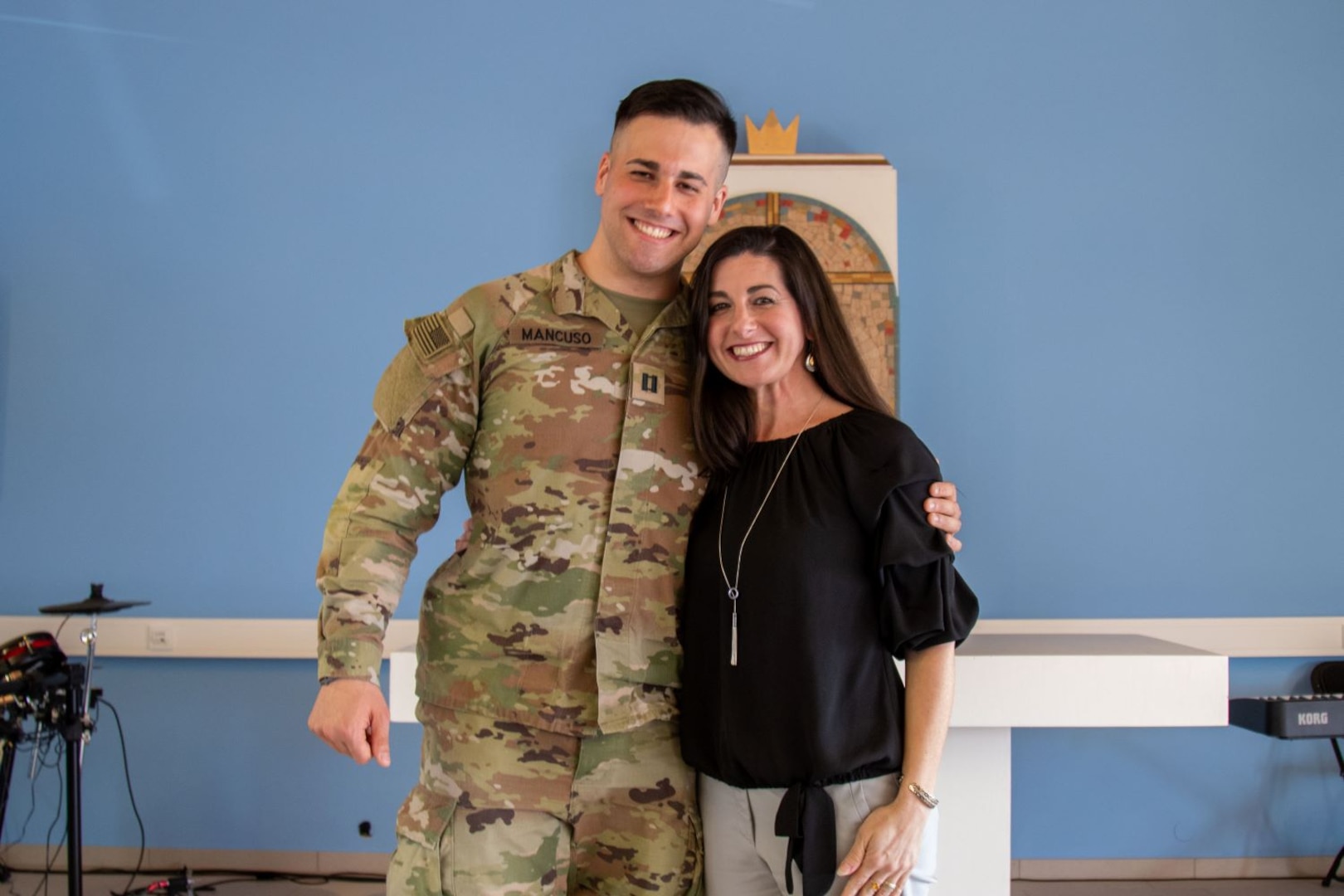 Service member smiles next to a woman in a black shirt