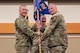 Men in uniform hold a flag.