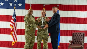 Gen. Anthony Cotton, U.S. Strategic Command commander (left), U.S. Air Force Col. James Schlabach, 91st Missile Wing commander (center), and Mr. Randy Norwood, Omaha Chamber assistant vice president (right), pose for a photo during the Omaha Trophy ceremony at Minot Air Force Base, North Dakota, July 9, 2025. The Omaha Trophy was awarded to the 91MW due to their exemplary readiness, performance and dedication to safeguarding national security.