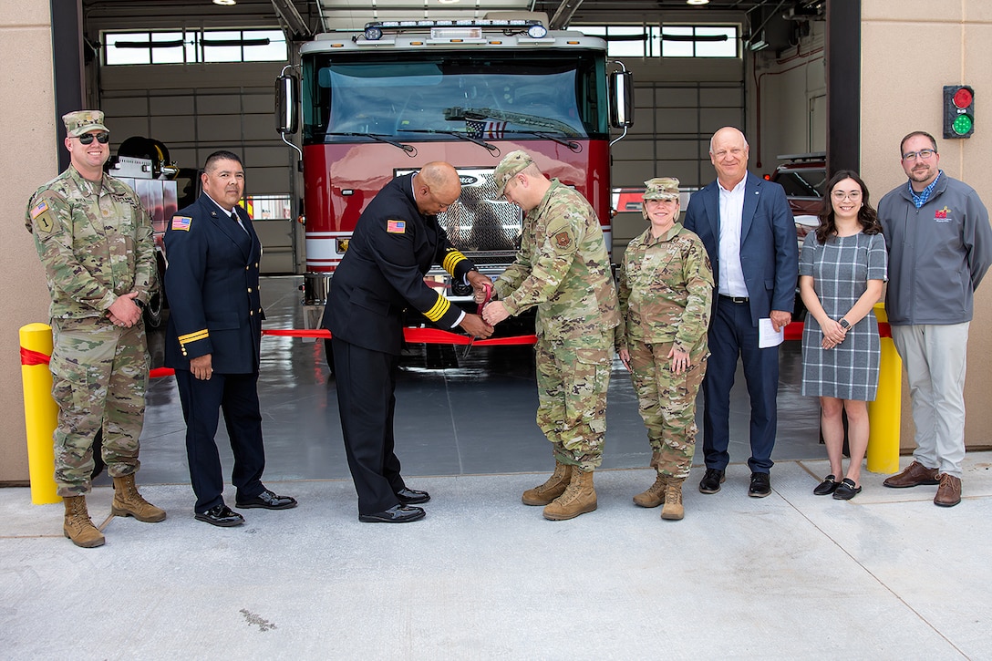 Kirtland AFB Fire Department Deputy Fire Chief Antwaun McClelland, 3rd from left, and Col Michael Power, commander, 377th Air Base Wing, cut the red ribbon and officially open Fire Station #3, June 13, 2025. USACE-Albuquerque District employees in the photo include Maj. Matthew Nulk, far left, contract specialist, and Jacob Pauley, far right, deputy district engineer.