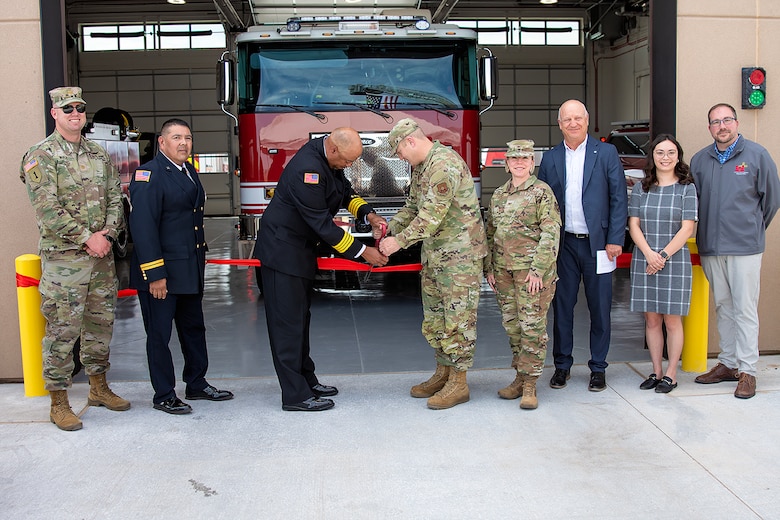 Kirtland AFB Fire Department Deputy Fire Chief Antwaun McClelland, 3rd from left, and Col Michael Power, commander, 377th Air Base Wing, cut the red ribbon and officially open Fire Station #3, June 13, 2025. USACE-Albuquerque District employees in the photo include Maj. Matthew Nulk, far left, contract specialist, and Jacob Pauley, far right, deputy district engineer.