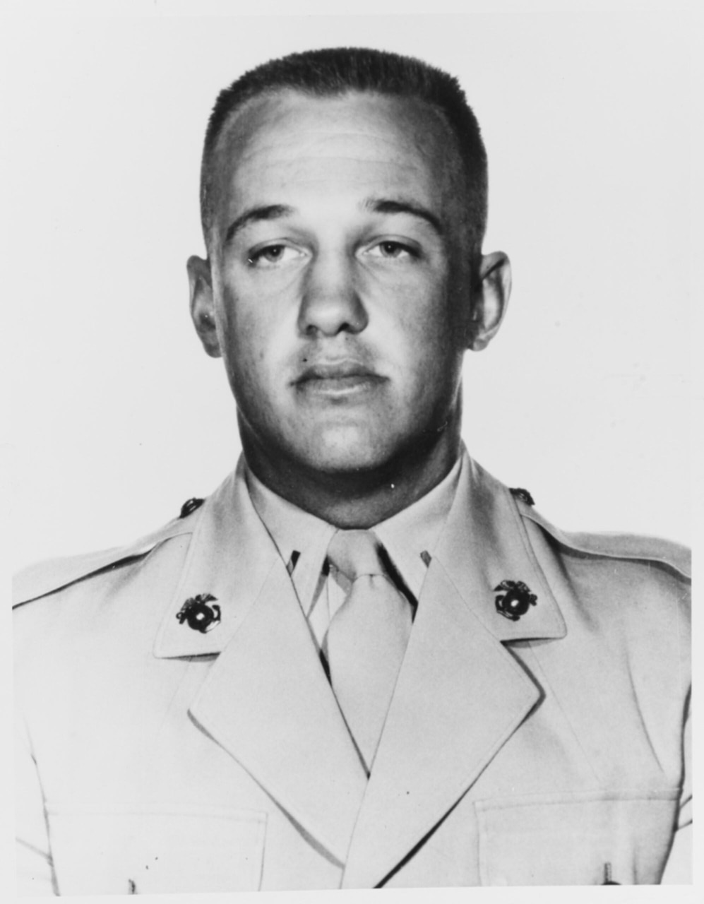A man in a military dress uniform poses for a photo.
