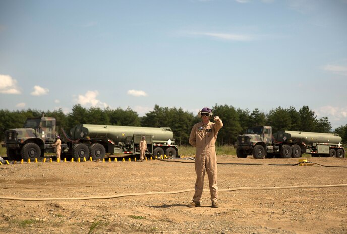 A U.S. Marine with Marine Wing Support Squadron 171 signals a Marine Heavy Helicopter Squadron 462 CH-53E Super Stallion rotary-wing aircraft to hold their position at Aibano Training Area, Sept. 15, 2015. MWSS-171 provided fuel for HMH-462 at a forward arming and refueling point during an assault transport. The assault transport supported a bilateral air assault comprehensive exercise during Forest Light 16-1. FL 16-1 is an exercise to increase interoperability of Japan Ground Self-Defense Force and U.S. Marine Corps forces. MWSS-171 is with Marine Aircraft Group 12, 1st Marine Aircraft Wing, III Marine Expeditionary Force. HMH-462 is with MAG 16, 3rd MAW, currently assigned to MAG 36, 1st MAW, III MEF.