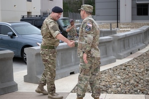 A senior member of the U.S. military greets a senior UK service member.