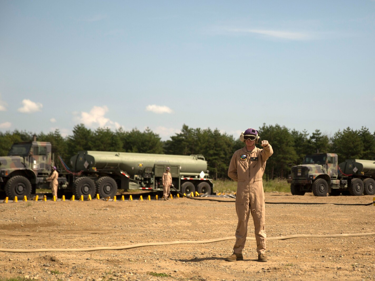 A U.S. Marine with Marine Wing Support Squadron 171 signals a Marine Heavy Helicopter Squadron 462 CH-53E Super Stallion rotary-wing aircraft to hold their position at Aibano Training Area, Sept. 15, 2015. MWSS-171 provided fuel for HMH-462 at a forward arming and refueling point during an assault transport. The assault transport supported a bilateral air assault comprehensive exercise during Forest Light 16-1. FL 16-1 is an exercise to increase interoperability of Japan Ground Self-Defense Force and U.S. Marine Corps forces. MWSS-171 is with Marine Aircraft Group 12, 1st Marine Aircraft Wing, III Marine Expeditionary Force. HMH-462 is with MAG 16, 3rd MAW, currently assigned to MAG 36, 1st MAW, III MEF.