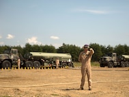 A U.S. Marine with Marine Wing Support Squadron 171 signals a Marine Heavy Helicopter Squadron 462 CH-53E Super Stallion rotary-wing aircraft to hold their position at Aibano Training Area, Sept. 15, 2015. MWSS-171 provided fuel for HMH-462 at a forward arming and refueling point during an assault transport. The assault transport supported a bilateral air assault comprehensive exercise during Forest Light 16-1. FL 16-1 is an exercise to increase interoperability of Japan Ground Self-Defense Force and U.S. Marine Corps forces. MWSS-171 is with Marine Aircraft Group 12, 1st Marine Aircraft Wing, III Marine Expeditionary Force. HMH-462 is with MAG 16, 3rd MAW, currently assigned to MAG 36, 1st MAW, III MEF.