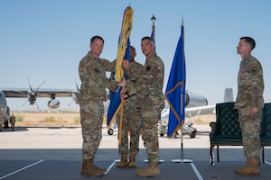 U.S. Air Force Maj. General David Lyons, 15th Air Force commander, presents the guidon to Col. Jose Cabrera, incoming 355th Wing commander, during the 355th Wing Change of Command ceremony at Davis-Monthan Air Force Base, Arizona, July 10, 2025. In this role, Cabrera will oversee the readiness, welfare and integration of more than 11,000 personnel across the installation. (U.S. Air Force photo by Airman Samantha Melecio)