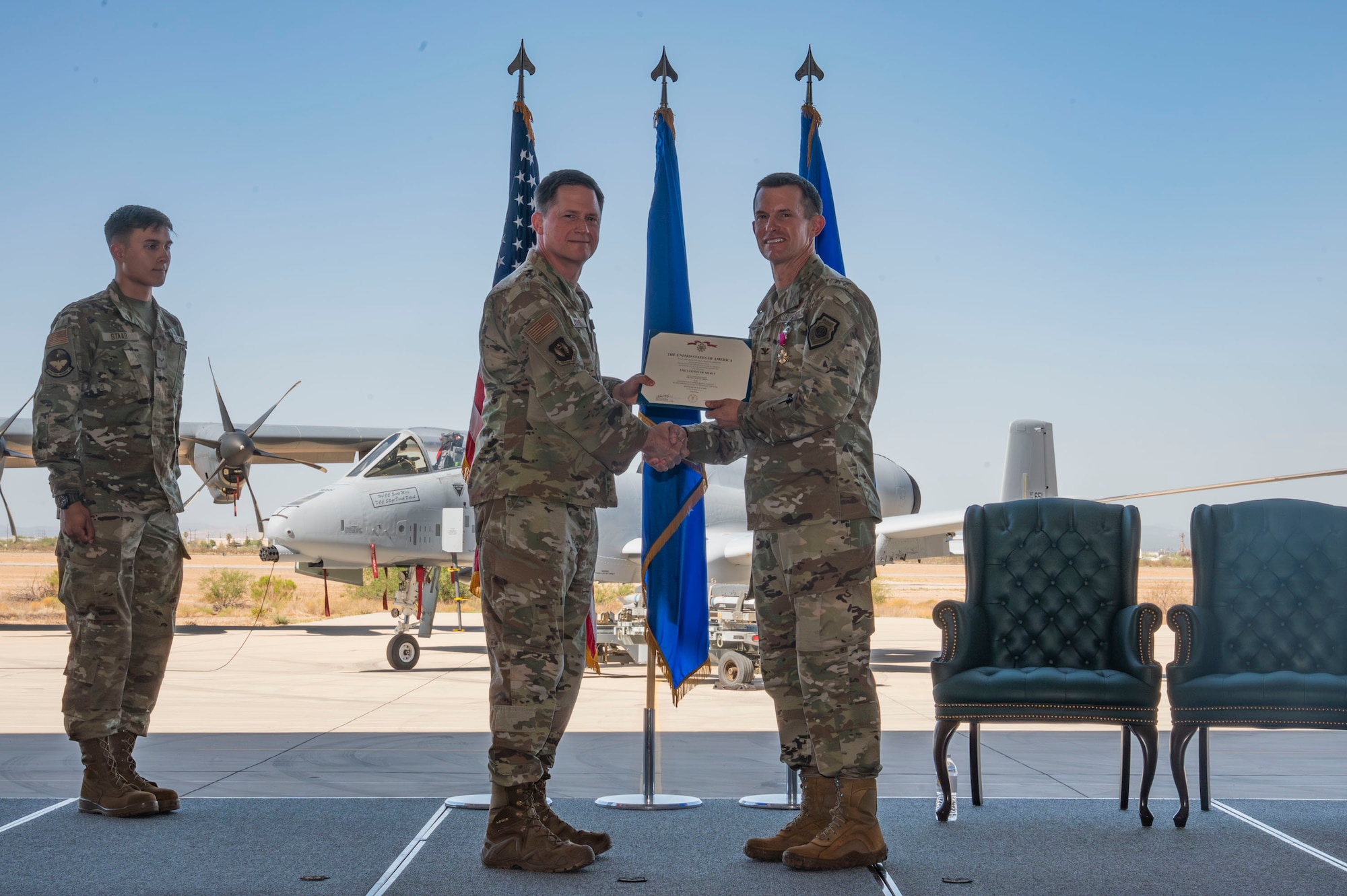U.S. Air Force Maj. General David Lyons, 15th Air Force commander, presents the Legion of Merit medal to Col. Scott Mills, outgoing 355th Wing commander, during the 355th Wing Change of Command ceremony at Davis-Monthan Air Force Base, Arizona, July 20, 2025. Mills concluded his three-year tenure as 355th Wing commander and departed Davis-Monthan to serve at the Pentagon as senior executive to the Air Force Chief of Staff. (U.S. Air Force photo by Airman Samantha Melecio)