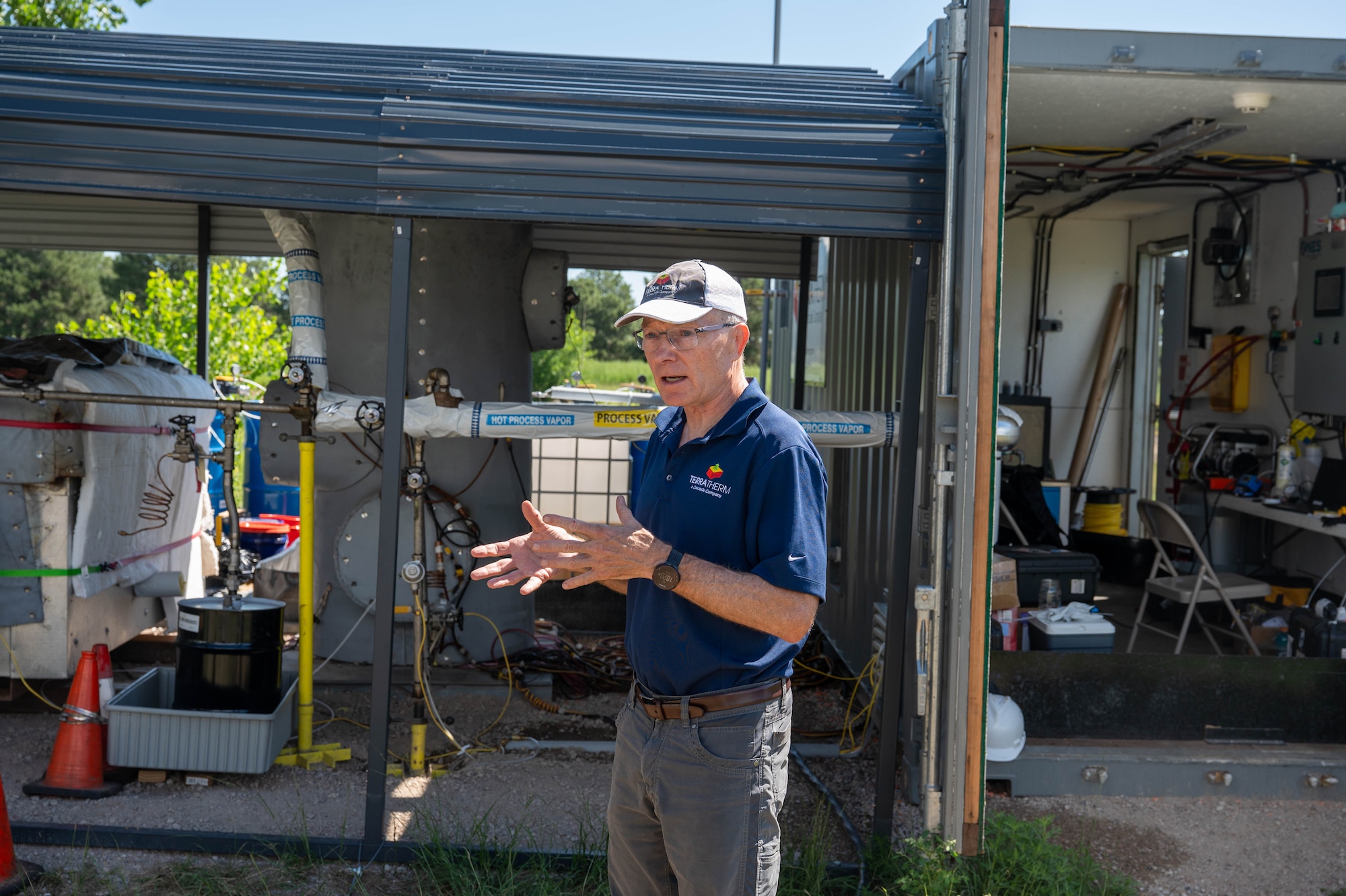 A man stands in front of heavy equipment used to remove PFAS from water