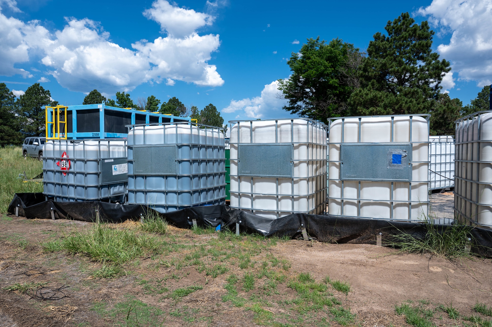 Containers of liquid sit in a field