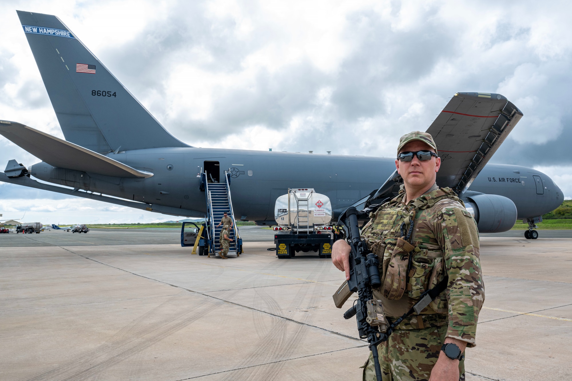 An Ohio ANG security forces member stands guard in front of a New Hampshire ANG KC-46A Pegasus.