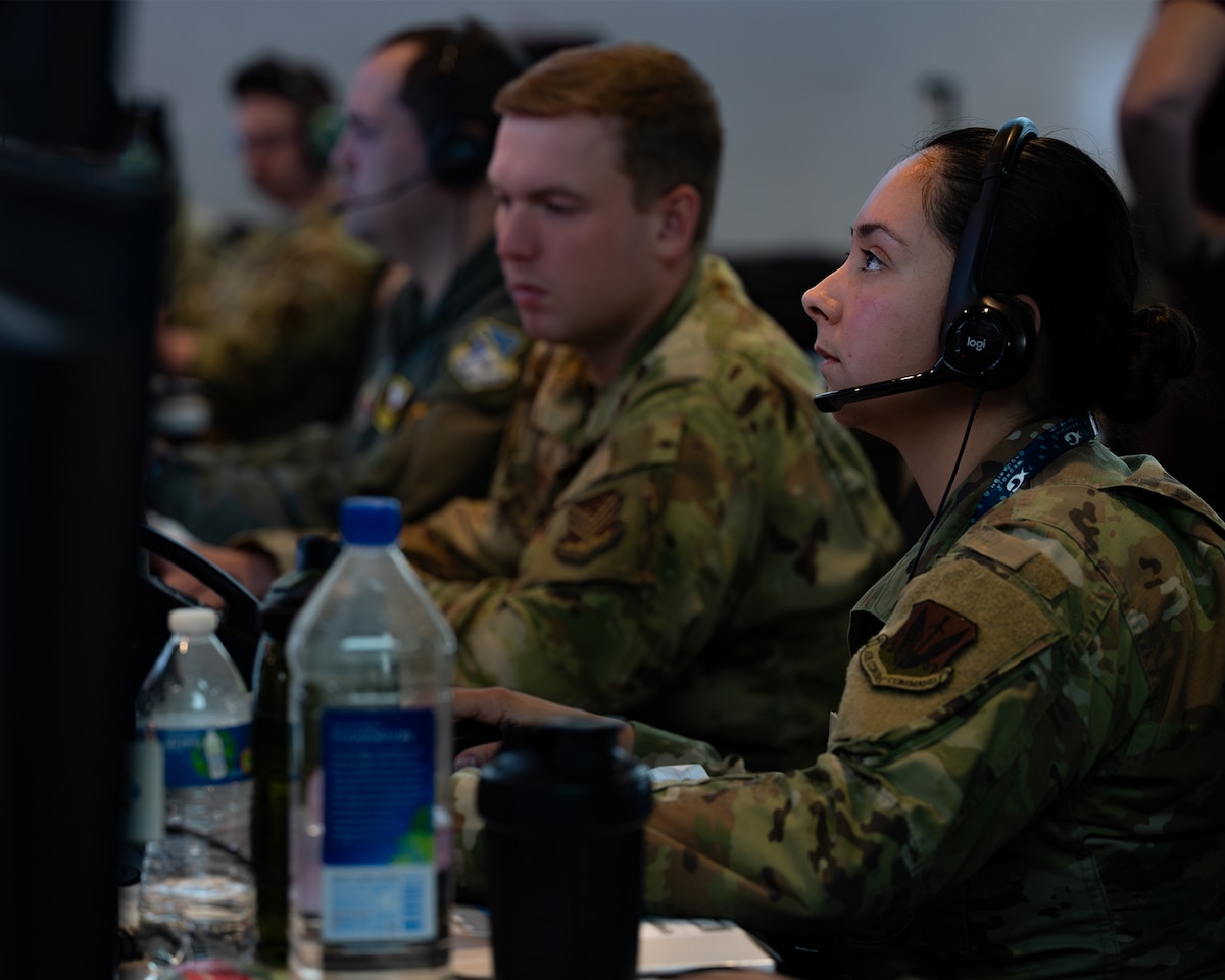 photo of US Airmen wearing headsets working on computers