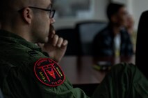 A temporary duty pilot assigned to the 119th Expeditionary Fighter Squadron listens during an exercise Resolute Force Pacific (REFORPAC) 2025 mission brief.