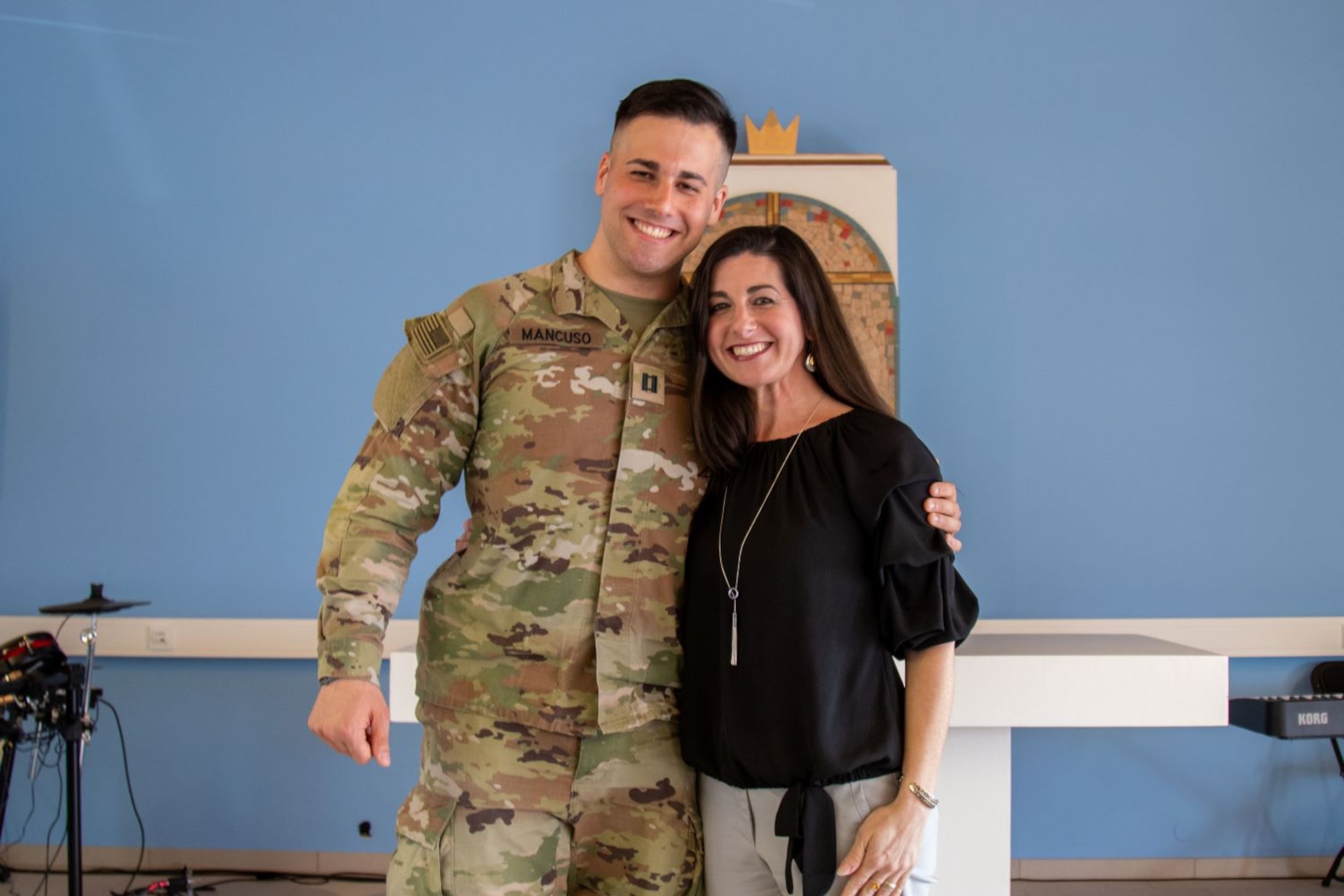 Service member smiles next to a woman in a black shirt