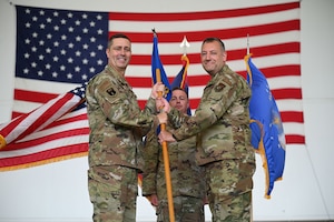 Photo of a commander passing a guidon during a change of command ceremony