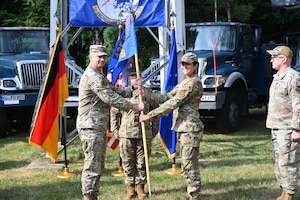 KAPAUN AIR STATION, Germany -- Col. Scott A. Weed, 435th Communications Operations Group commander (Left) passes the guidon to Maj. Lesly M. Torres, during the 1st Engineering Installation Squadron change of command at Kapaun Air Station, July 3, 2025. The ceremony highlighted the departure of Maj. Caleb E. Mays and the accomplishments of the squadron during his leadership while also outlining Torres’s capabilities in leading the squadron. (U.S Air Force photo by Capt. Lou Burton)