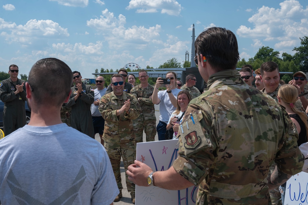 A man holds a sign in front of a crowd