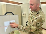 Soldier positions a patient for an X-Ray.