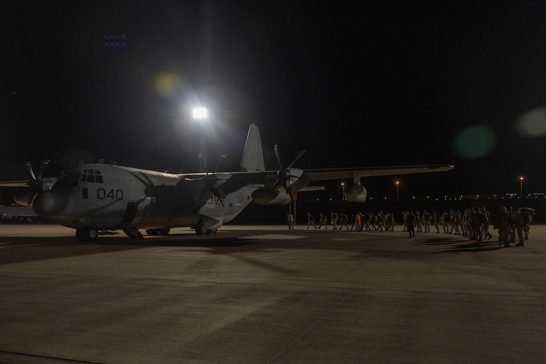 U.S. Marines with 2nd Low Altitude Air Defense Battalion, Marine Air Control Group 28, 2nd Marine Aircraft Wing, walk across the airstrip with their gear upon arrival to Aqaba, Jordan, for exercise Native Fury 25, June 26, 2025. Native Fury 25 is a biannual exercise focused on the demonstration of the rapid offload and integration of a Maritime Prepositioned Force in the U.S. Central Command area of responsibility in support of regional security, crisis response, and contingency operations. (U.S. Marine Corps photo by Lance Cpl. Isabella Ramos)