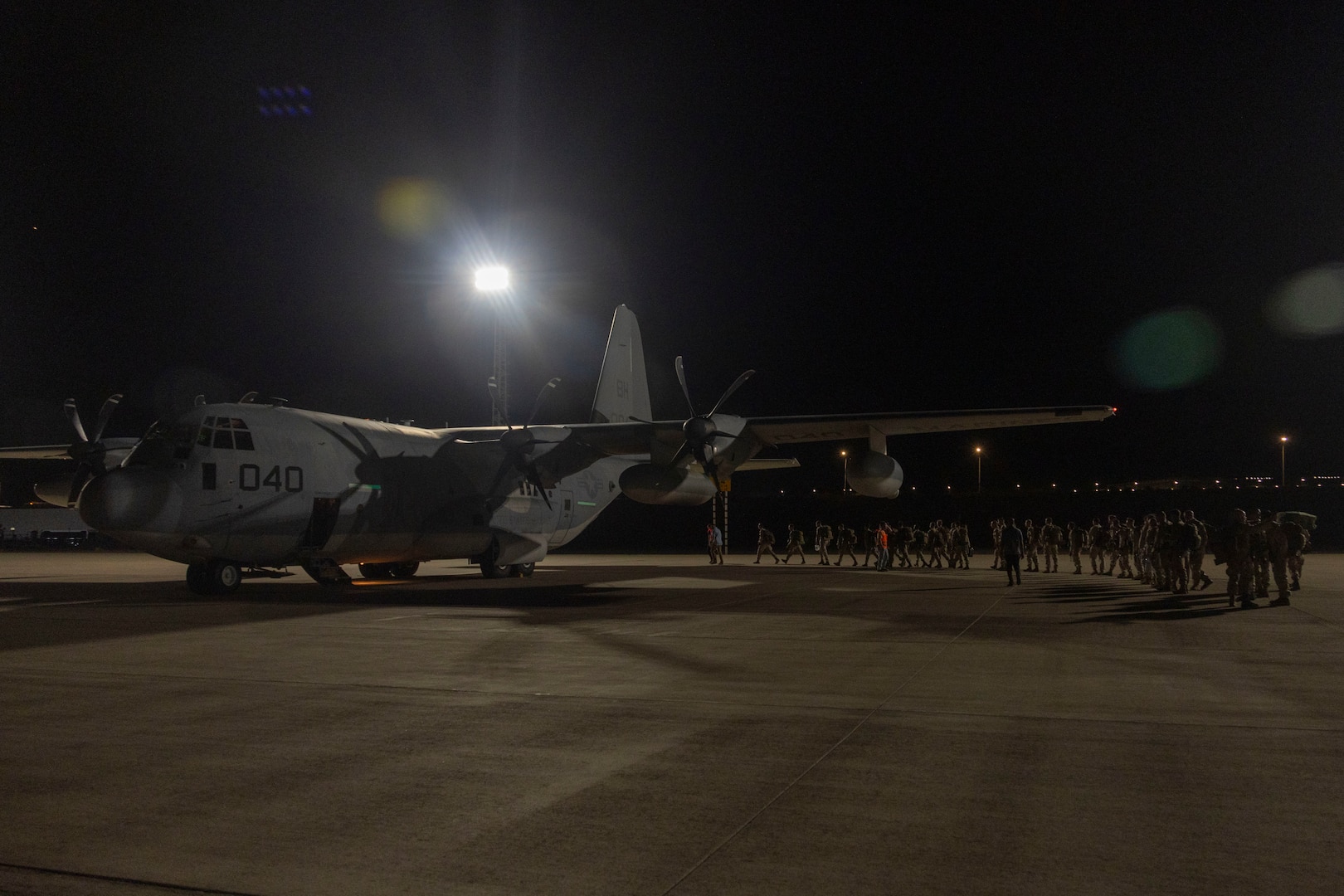 U.S. Marines with 2nd Low Altitude Air Defense Battalion, Marine Air Control Group 28, 2nd Marine Aircraft Wing, walk across the airstrip with their gear upon arrival to Aqaba, Jordan, for exercise Native Fury 25, June 26, 2025. Native Fury 25 is a biannual exercise focused on the demonstration of the rapid offload and integration of a Maritime Prepositioned Force in the U.S. Central Command area of responsibility in support of regional security, crisis response, and contingency operations. (U.S. Marine Corps photo by Lance Cpl. Isabella Ramos)