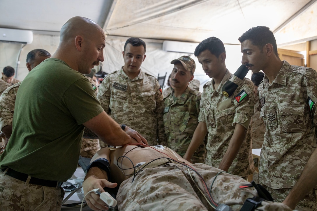 U.S. Navy Hospital Corpsman 2nd Class Zachary McBride with 2nd Medical Battalion, 2nd Marine Logistics Group gives a demonstration on proper CPR techniques to Jordanian personnel with the Royal Medical Service during a medical education class as part of exercise Native Fury 25 in Jordan, June 30, 2025. Native Fury 25 is a biannual exercise focused on the demonstration of the rapid offload and integration of a Maritime Prepositioned Force in the U.S. Central Command area of operations in support of regional security, crisis response, and contingency operations. (U.S. Marine Corps photo by Lance Cpl. Isabella Ramos)