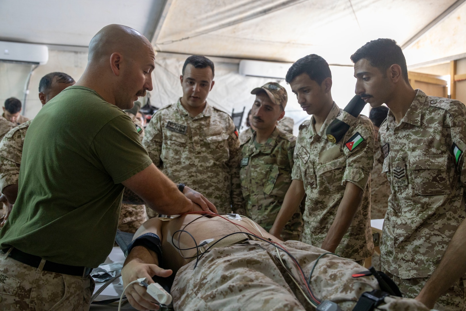 U.S. Navy Hospital Corpsman 2nd Class Zachary McBride with 2nd Medical Battalion, 2nd Marine Logistics Group gives a demonstration on proper CPR techniques to Jordanian personnel with the Royal Medical Service during a medical education class as part of exercise Native Fury 25 in Jordan, June 30, 2025. Native Fury 25 is a biannual exercise focused on the demonstration of the rapid offload and integration of a Maritime Prepositioned Force in the U.S. Central Command area of operations in support of regional security, crisis response, and contingency operations. (U.S. Marine Corps photo by Lance Cpl. Isabella Ramos)
