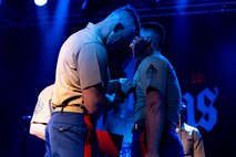 U.S. Marine Corps Cpl. William Pfaff, the bass player of the Quantico Marine Rock Band, assigned to Special Purpose Marine Air-Ground Task Force-250, right, receives the U.S. Marine Corps Good Conduct Medal from U.S. Marine Corps Maj. Heath Gomez, the Special Purpose Marine Air-Ground Task Force-250 Executive Officer at Rookies RocHaus in West Dundee, Illinois, as part of Marine Week Chicago, July 10, 2025. The awards and reenlistment ceremony highlighted Pfaff's accomplishments and decision to continue to serve, represent, and carry the U.S. Marine Corps’ core values of honor, courage and commitment. Throughout the year, Marines across the globe will celebrate the 250th birthday of the Corps, commemorating service, sacrifice, and priding themselves on living ‘Semper Fidelis’ or ‘Always Faithful’ to their nation and to each other. (U.S. Marine Corps photo by Lance Cpl. Elijua Guel)