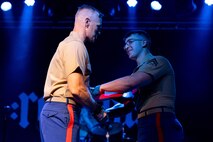 U.S. Marine Corps Cpl. William Pfaff, right, the bass player of the Quantico Marine Rock Band, assigned to Special Purpose Marine Air-Ground Task Force-250, receives a certificate from U.S. Marine Corps Maj. Heath Gomez, the Special Purpose Marine Air-Ground Task Force-250 company executive officer at Rookies RocHaus in West Dundee, Illinois, as part of Marine Week Chicago 2025, July 10, 2025. The reenlistment ceremony highlighted Pfaff's accomplishments and decision to continue to serve, represent, and carry the U.S. Marine Corps’ core values of honor, courage and commitment. Throughout 2025, Marines across the globe will celebrate the 250th birthday of the Corps, commemorating service, sacrifice, and priding themselves on living ‘Semper Fidelis’ or ‘Always Faithful’ to their nation and to each other. (U.S. Marine Corps photo by Lance Cpl. Elijua Guel)
