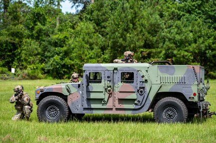 Airman taking cover by vehicle