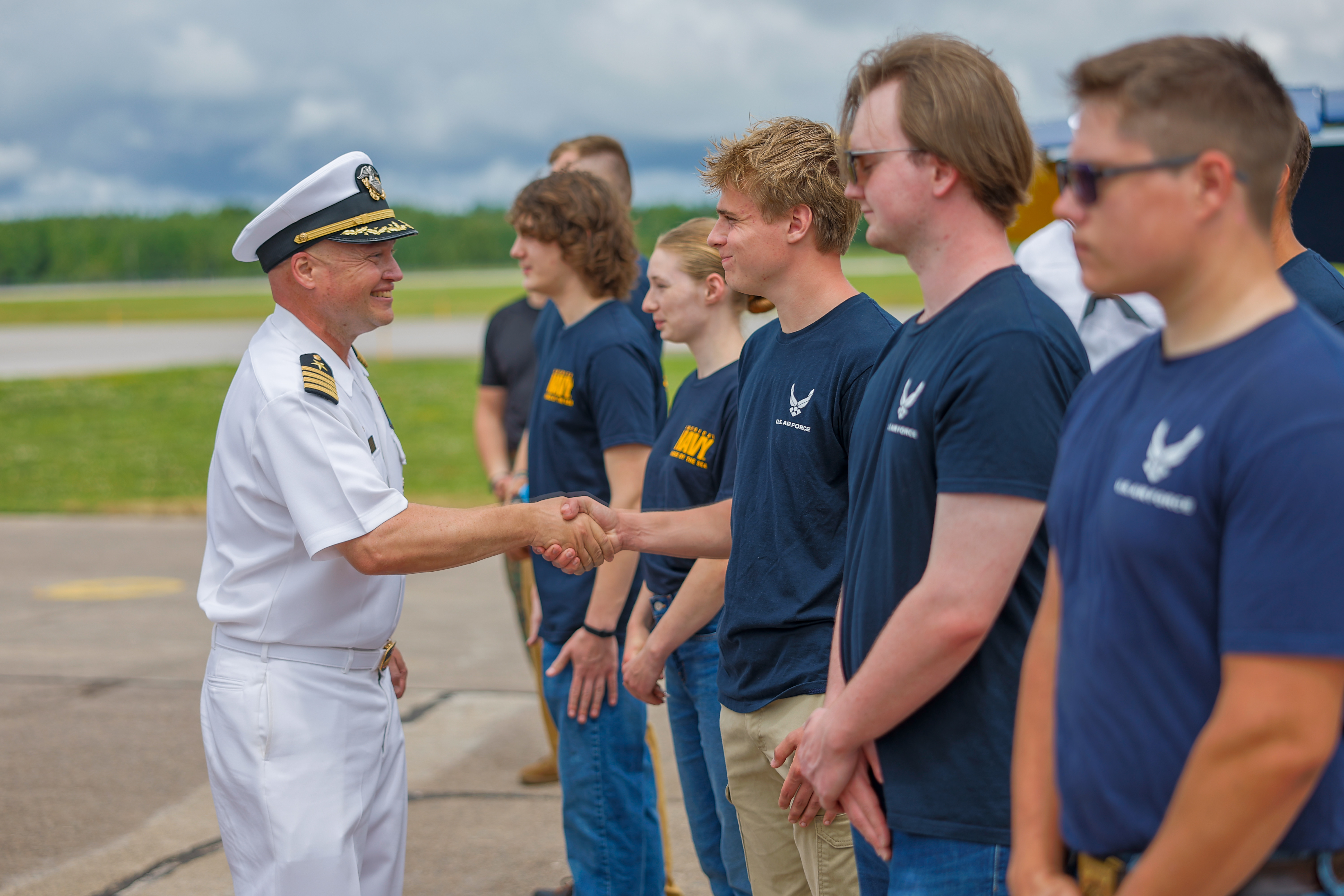 Captain Dale Gregory Jr. of USS Ronald Reagan (CVN 76) shakes the hands of new service members after administering the oath of enlistment to future Sailors and other future service members during a public swear-in ceremony at the Duluth Airshow during Duluth Navy Week.