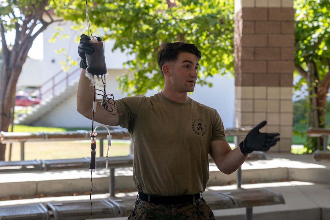 U.S. Navy Hospital Corpsman 3rd Class Demitri Lynch, combat trauma management instructor assigned to 1st Marine Division Schools, demonstrates how to give a patient blood during a transfusion demonstration at Marine Corps Base Camp Pendleton, California, July 9, 2025. The Valkyrie Program was developed to expand the capabilities of general corpsmen and Marines by providing training in blood transfusion procedures. (U.S. Marine Corps photo by Lance Cpl. Aimee Jordan)