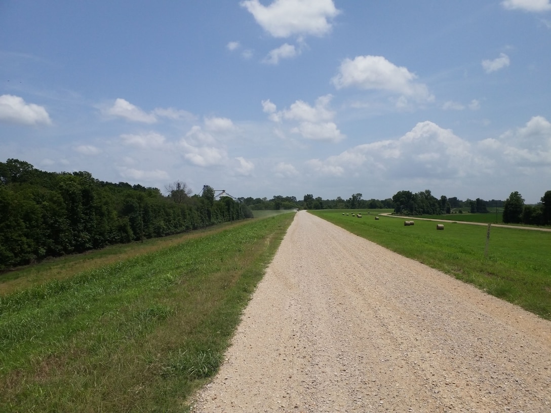Well-maintained, recently mowed levee slope with grasses baled and ready for removal.