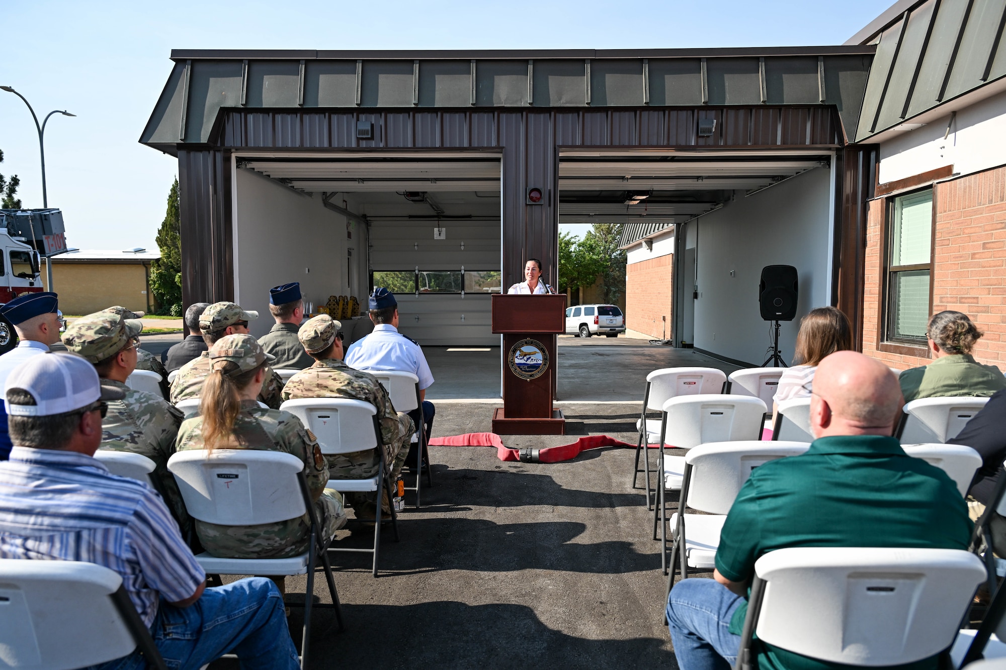Speaker in front of a fire station speaking to an audience