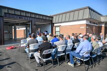 Speaker in front of a fire station speaking to an audience