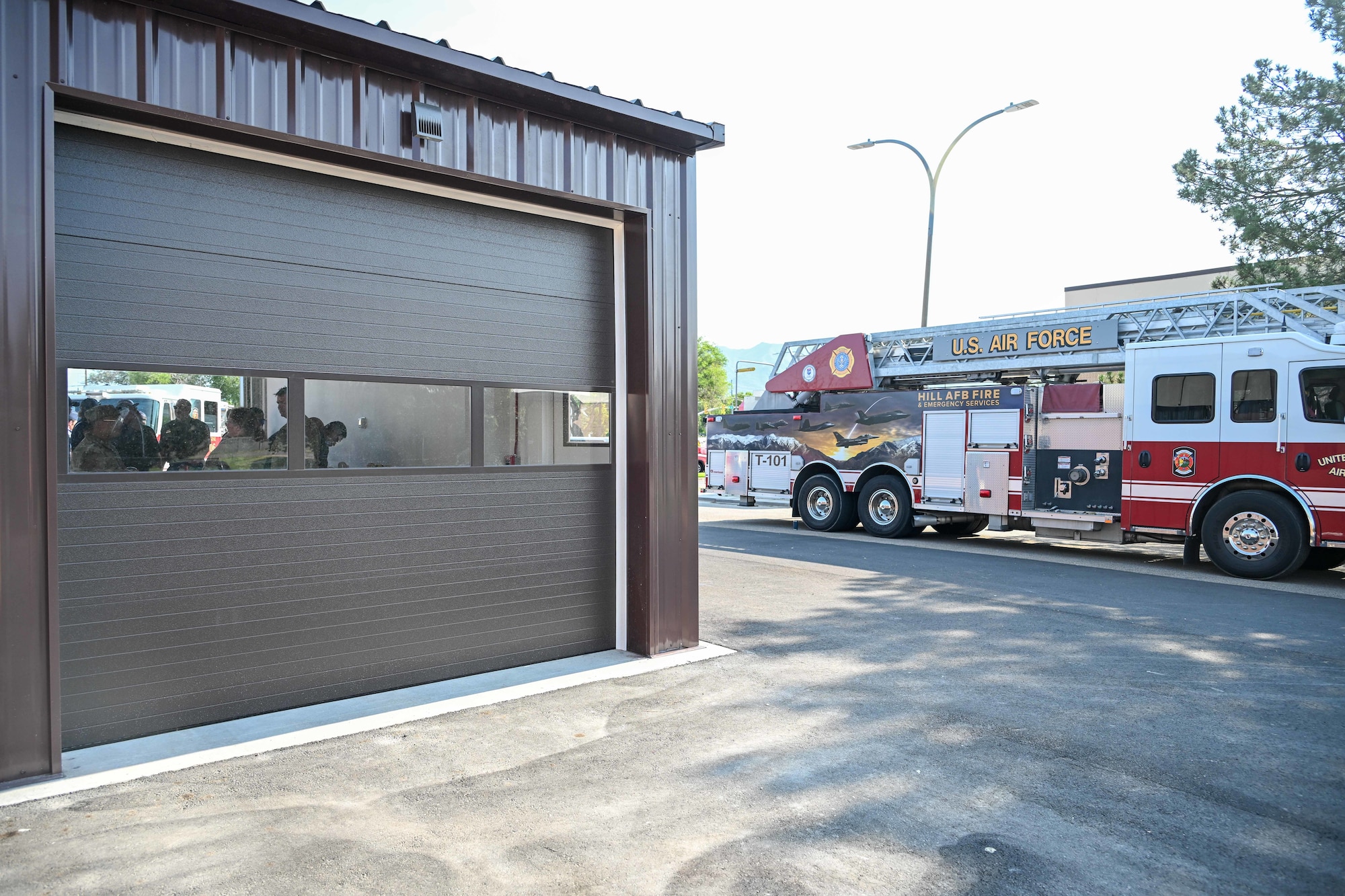 A fire station bay in foreground with a fire engine truck in background