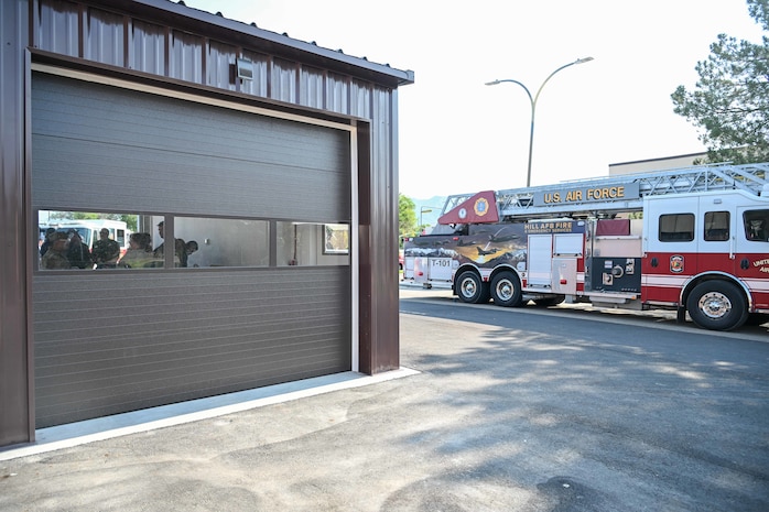 A fire station bay in foreground with a fire engine truck in background