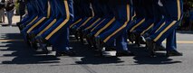 Legs of Army Soldiers who are dressed in ceremonial uniforms and marching in a parade.