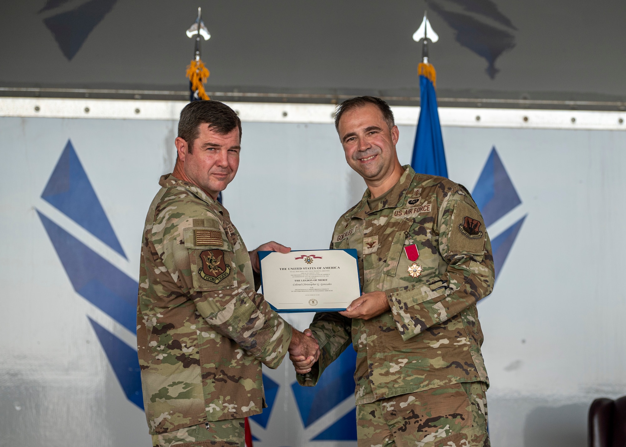 U.S. Air Force Col. Paul Sheets, 23rd Wing commander, presents Col. Christopher Gonzales, 23rd Medical Group commander, with the Legion of Merit award at Moody Air Force Base, Georgia, July 11, 2025. The award honored Col. Gonzales for his outstanding leadership and dedication to medical readiness across the 23rd Wing. (U.S. Air Force photo by Senior Airman Leonid Soubbotine)
