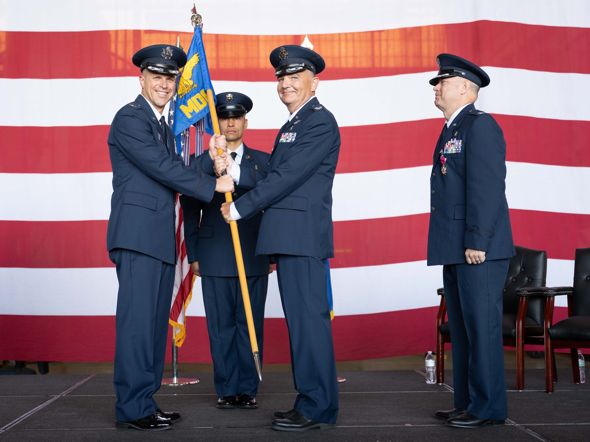 Col. Darren Damiani assumes command of the 7th Medical Group from Col. Seth Spanier, 7th Bomb Wing commander, during a change of command ceremony at Dyess Air Force Base, Texas, July 9, 2025. Col. Darren Damiani assumed command of the 7th MDG, overseeing safe, quality medical care and ensuring the medical readiness for all Dyess Airmen. (U.S. Air Force photo by Airman Caleb Schellenberg)