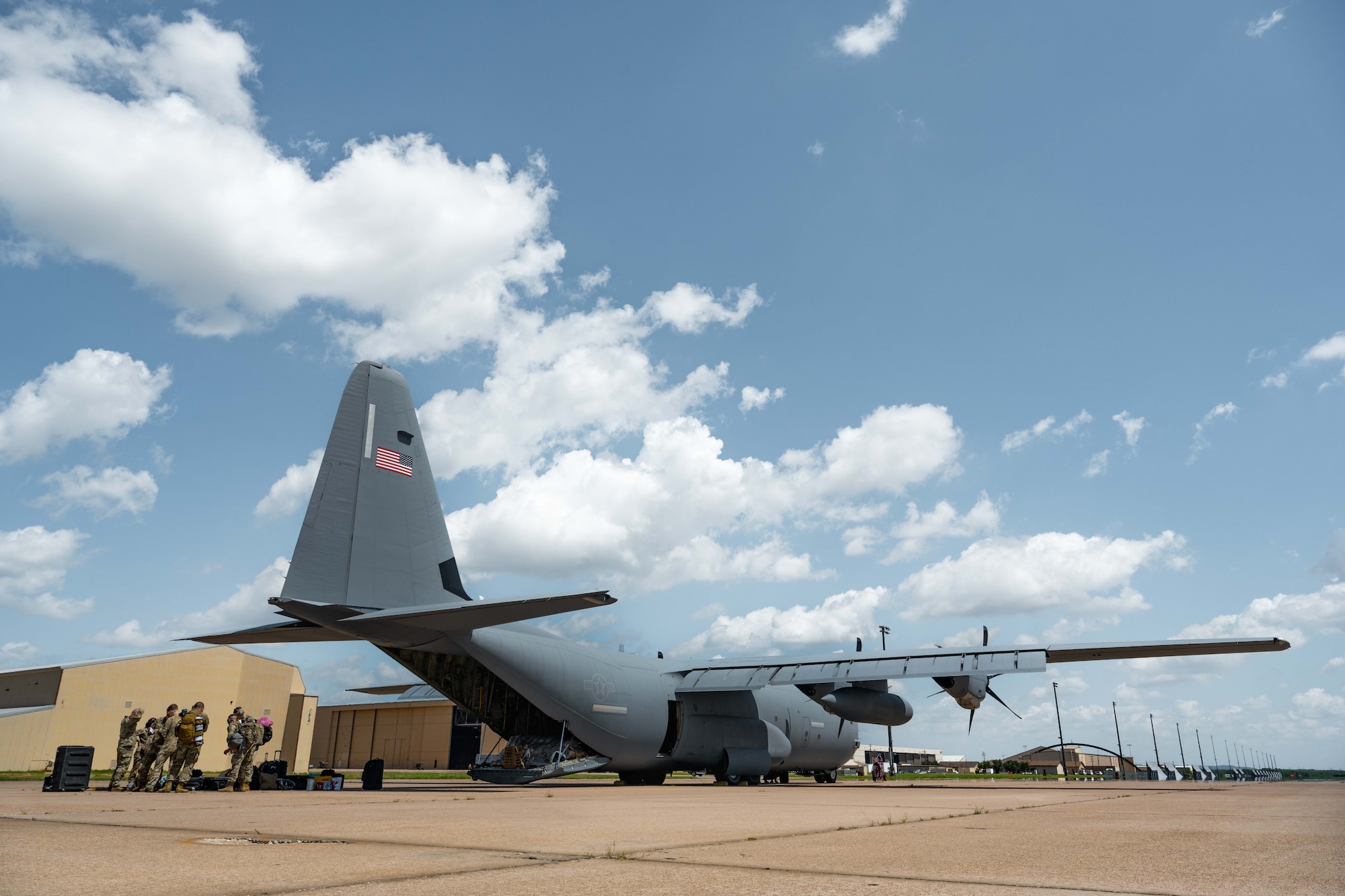 U.S. Airmen from Dyess Air Force Base prepare to load cargo onto a C-130J Super Hercules before a Max Endurance Operation in support of the 2025 Department-Level Exercise series at Dyess AFB, Texas, July 8, 2025. The 317th Airlift Wing demonstrated their and Air Mobility Command ability to rapidly deploy into the Indo-Pacific area of responsibility by utilizing multiple aircraft configured with external fuel tanks. The DLE series encompasses all branches of the Department of Defense, along with Allies and partners, employing more than 400 Joint and coalition aircraft and more than 12,000 members at more than 50 locations across 3,000 miles. (U.S. Air Force photo by Airman Caleb Schellenberg)