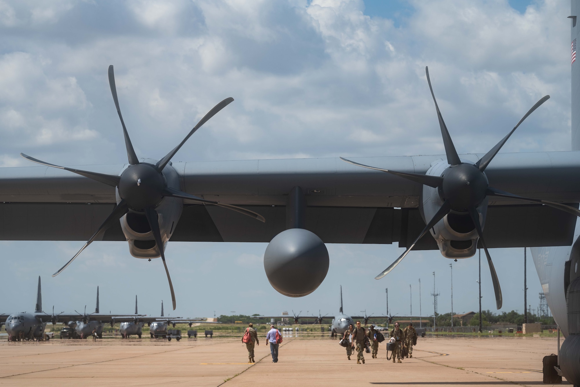 A U.S. Air Force C-130J Super Hercules equipped with external fuel tanks, assigned to the 39th Airlift Squadron, sits on the flightline before a Max Endurance Operation in support of the 2025 Department-Level Exercise series at Dyess Air Force Base, Texas, July 8, 2025. The integration of external fuel tanks not only enhances the wing and Air Mobility Command’s ability to reach remote locations with less fuel stops but also provides the flexibility to carry extra fuel to offload for joint forces in austere locations. The DLE series encompasses all branches of the Department of Defense, along with Allies and partners, employing more than 400 Joint and coalition aircraft and more than 12,000 members at more than 50 locations across 3,000 miles. (U.S. Air Force photo by Airman Caleb Schellenberg)