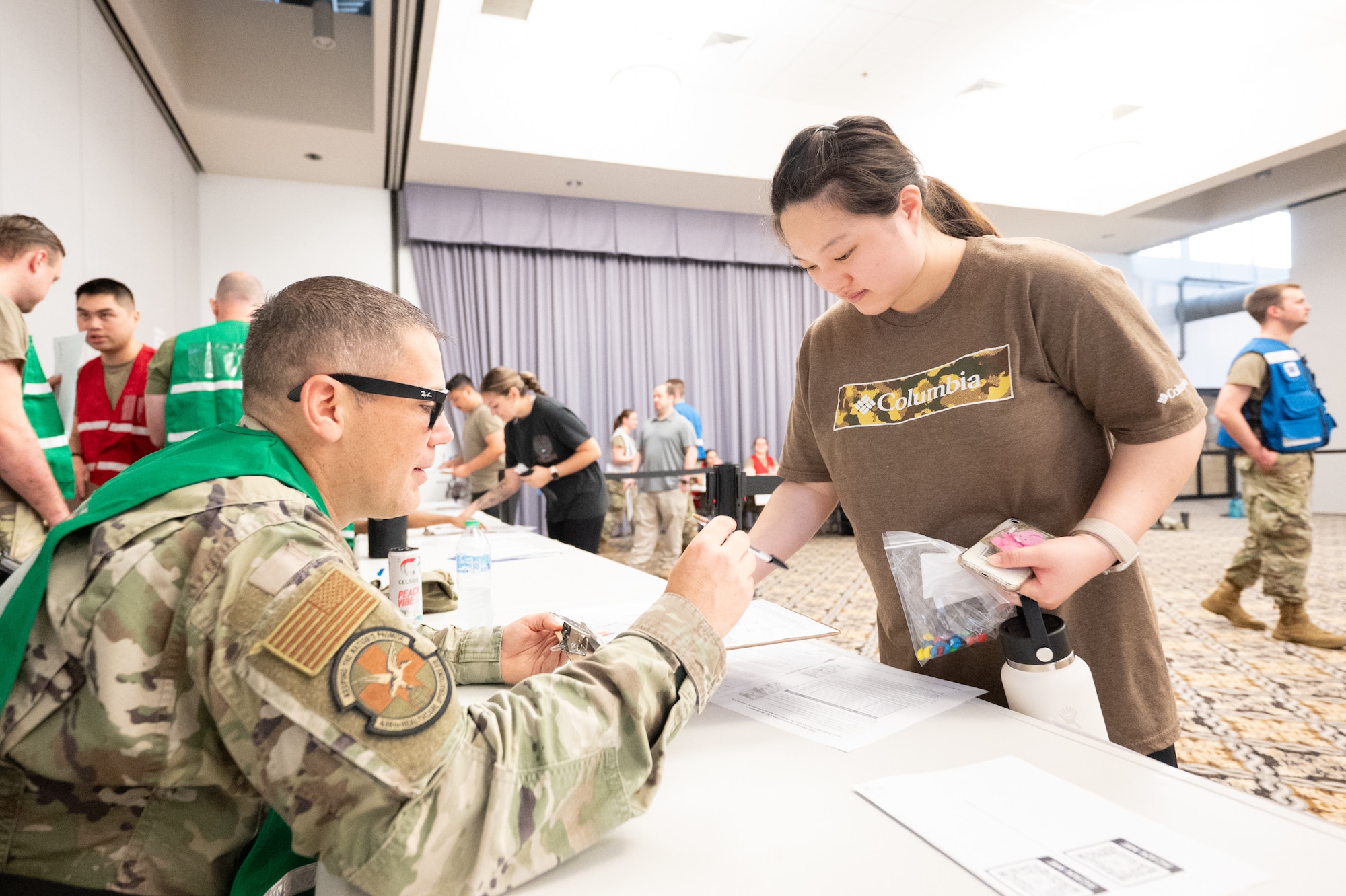U.S. Air Force Master Sgt. Matthew Amiot, 436th Healthcare Operations Squadron pharmacy flight chief, dispenses simulated medication to a patient during a biohazard disaster response exercise conducted by the 436th Medical Group at Dover Air Force Base, Delaware, June 9, 2025. The exercise challenged medical staff on how to triage and treat personnel after being exposed to simulated Anthrax. (U.S. Air Force photo by Mauricio Campino)