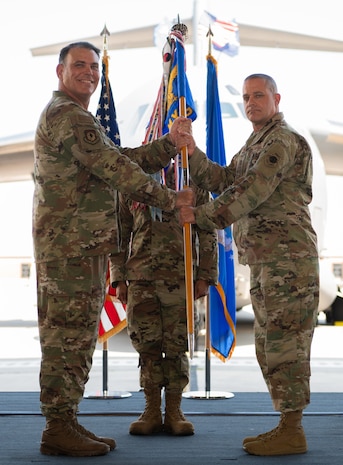 Two U.S. AirForce Colonel hold the guidon during the unit's assumption of command.