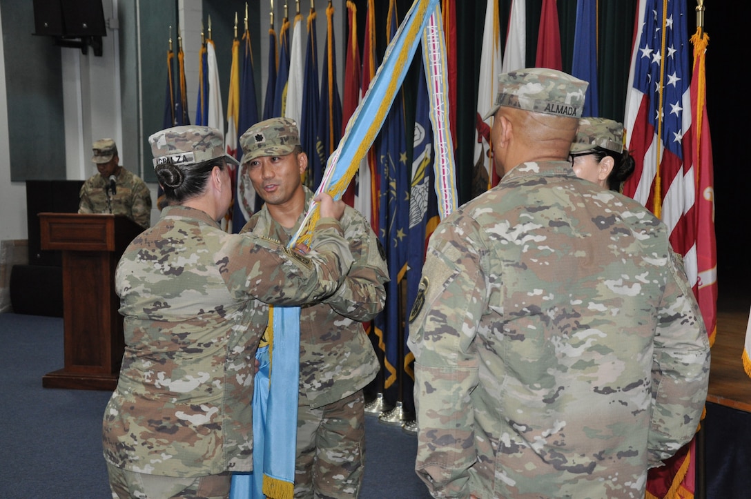 Person passes colors during change of command ceremony.