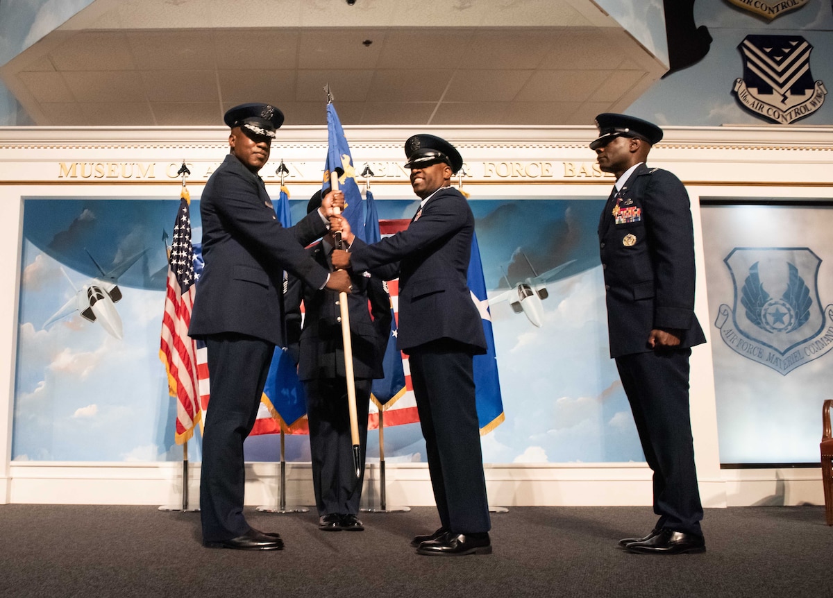 Col. Johari Hemphill, middle, incoming 78th Air Base Wing commander, takes the 78th ABW guidon from Lt. Gen. Stacey Hawkins, left, Air Force Sustainment Center commander, after Col. Deedrick Reese, outgoing 78th ABW commander, relinquished his command during the 78th ABW change of command ceremony at Robins Air Force Base, Georgia, July 9, 2025
