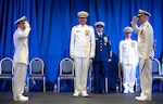 Coast Guard officers salute during a change of command ceremony